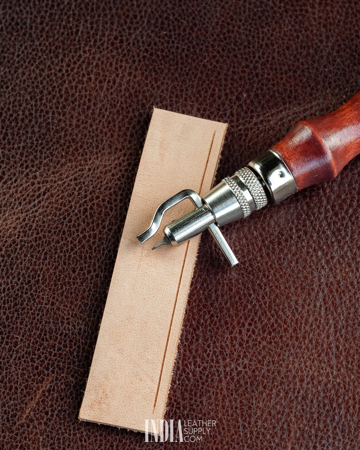 Groover, Creaser & Beveller Multi-Tool | Edge guide riding along a veg-tan strap | India Leather Supply