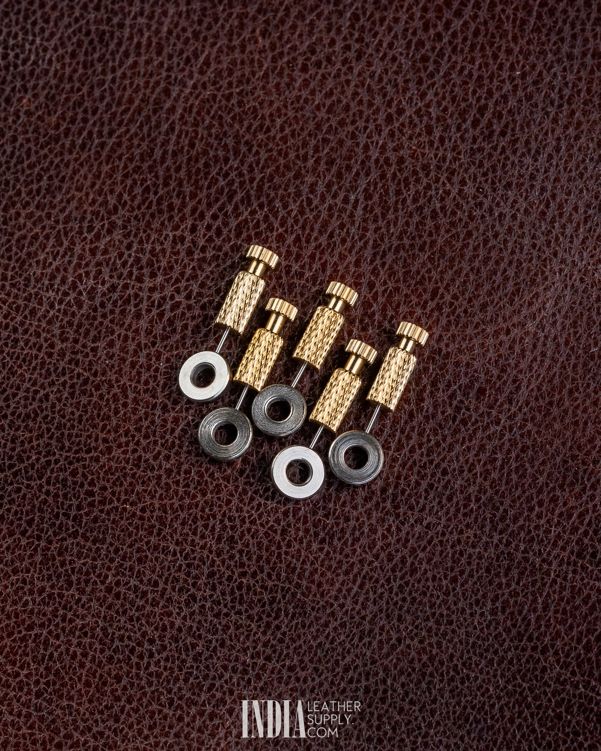 Five brass positioning needles with black and silver washers